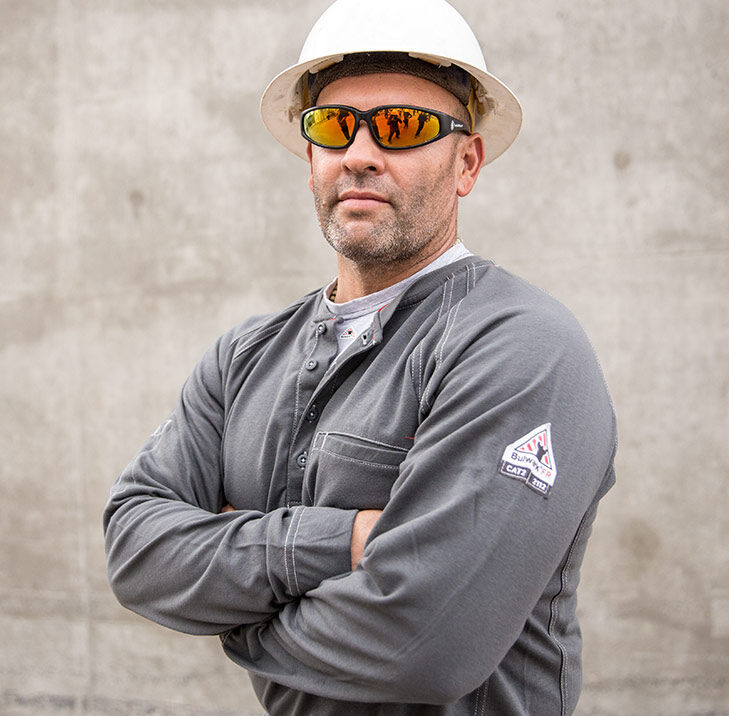 A Man In A Hard Hat With Crossed Arms